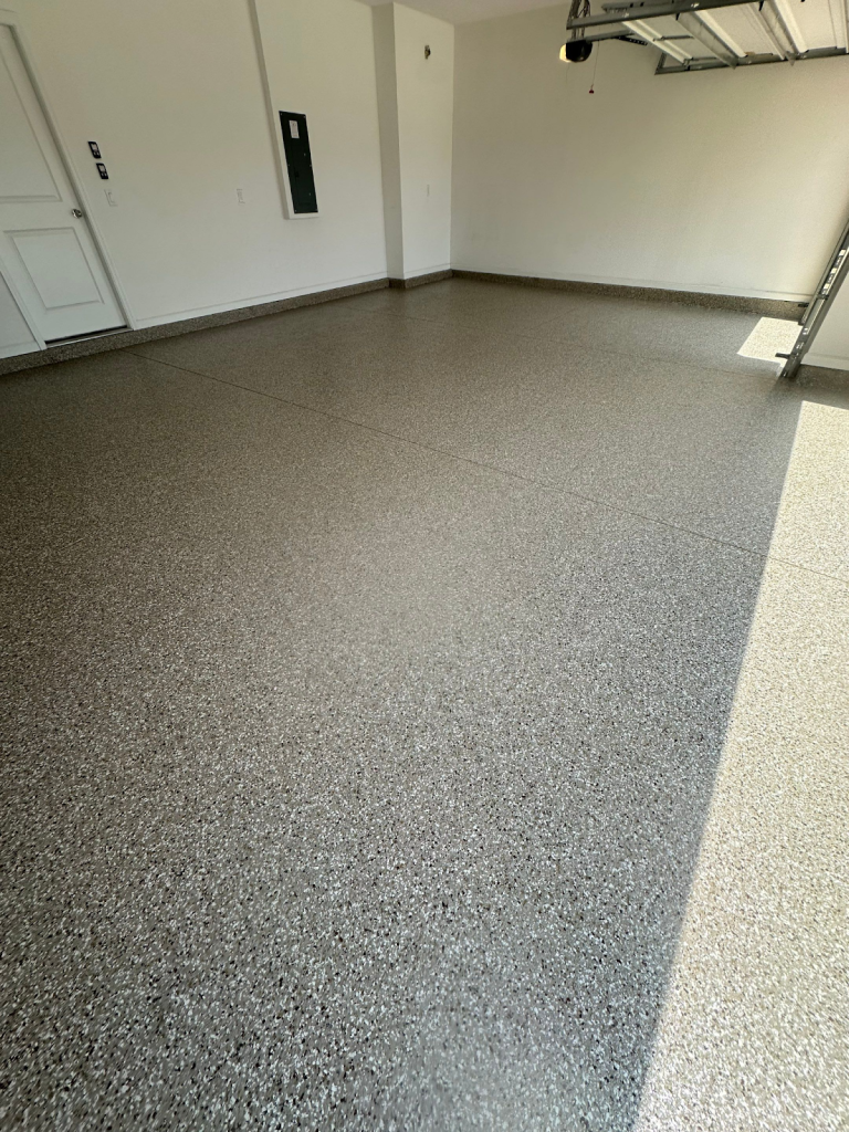Garage floor coated with decorative brown and gray flake finish