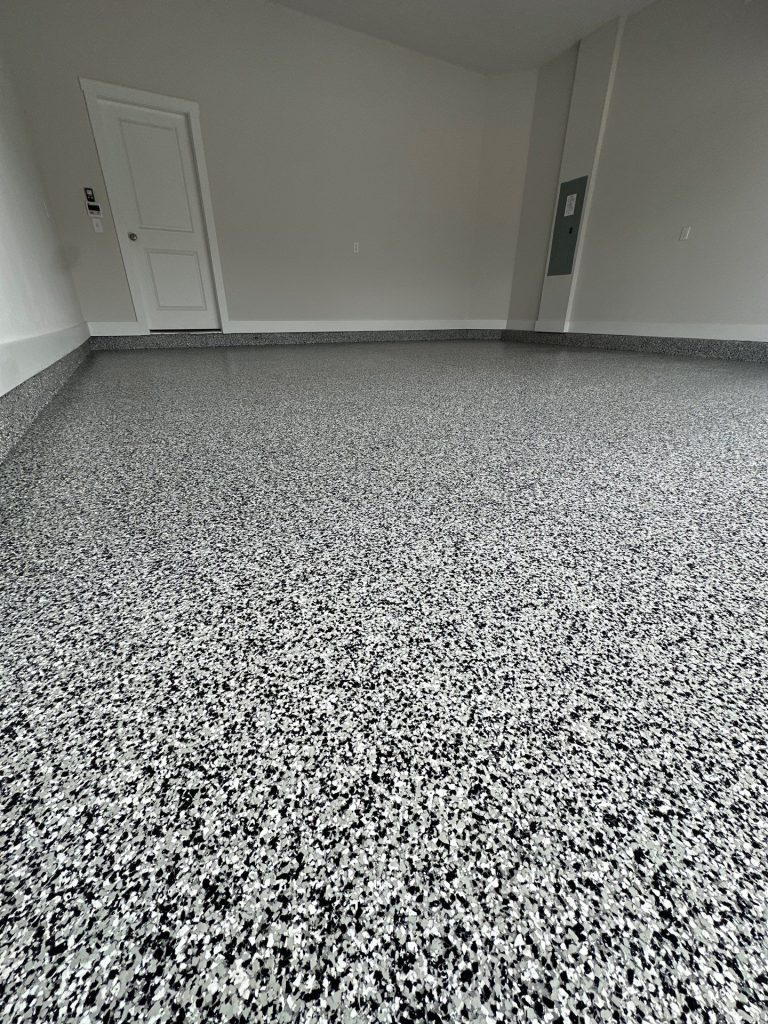 Garage floor coated with black, white, and gray flake finish