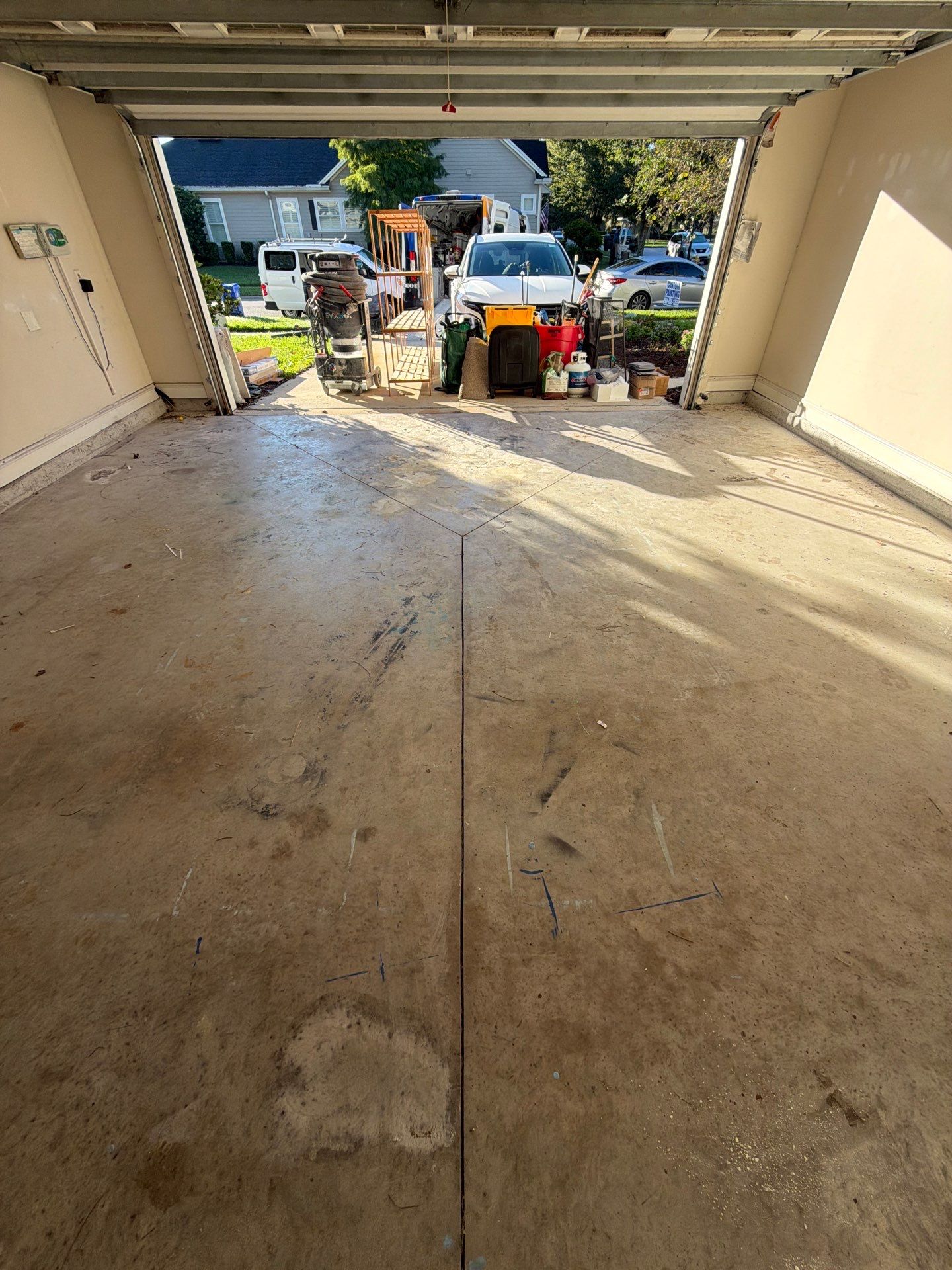 Bare, stained new-construction garage slab in Nocatee before coating